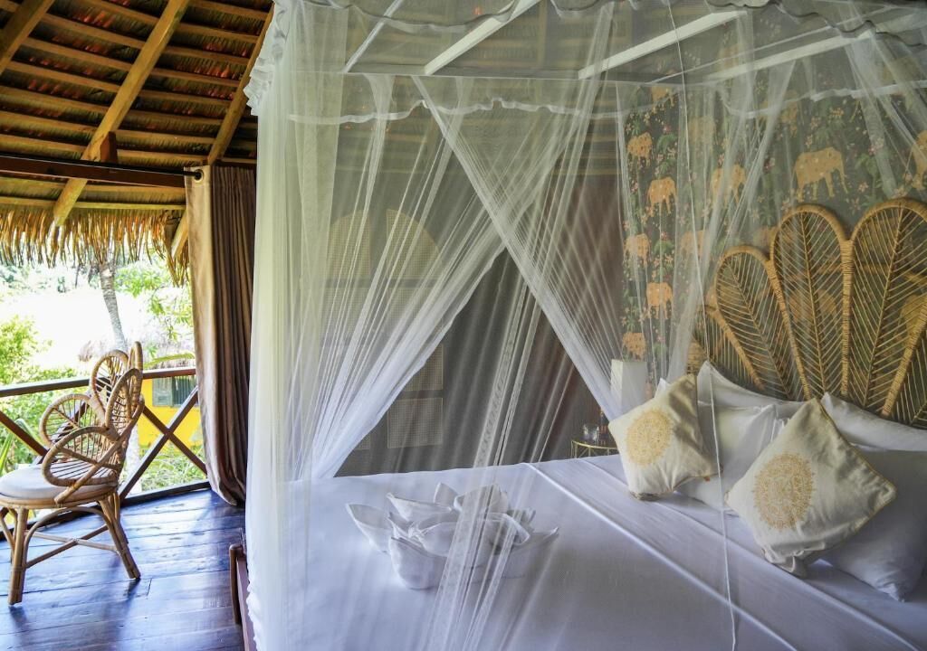 Une chambre avec un lit, une chaise et une vue sur la verdure.