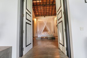 A hotel room with a bed, a canopy, and a view of the ceiling. - Huma Terra Lodge (Hikkaduwa)