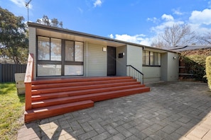 A modern two-story house with a front porch and a brick driveway. - Family-Friendly 3-Bed House in Kambah (Kambah)