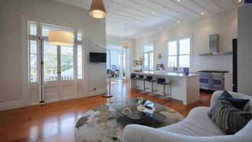 A spacious living area with a sofa, a coffee table, and a kitchen in the background.