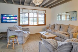 A living room with two sofas, a coffee table, and a television mounted on the wall. - Paper Bark Cabin – Dunsborough (Dunsborough)
