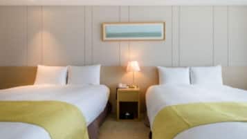 A hotel room with two beds, a nightstand with a lamp, and a framed picture on the wall.