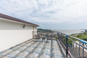 Una terraza en la azotea con mobiliario exterior y vistas al mar.
