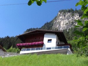 A chalet with a balcony, surrounded by greenery and a mountainous backdrop. - Zuppinger by Interhome (Mayrhofen)
