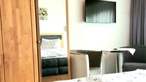 A hotel room with a bed, a desk, a chair, and a television on the wall. - Zuppinger by Interhome (Mayrhofen)