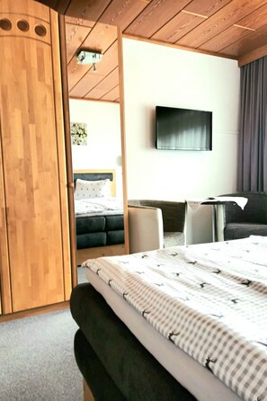 A hotel room with a bed, a desk, a chair, and a television on the wall. - Zuppinger by Interhome (Mayrhofen)