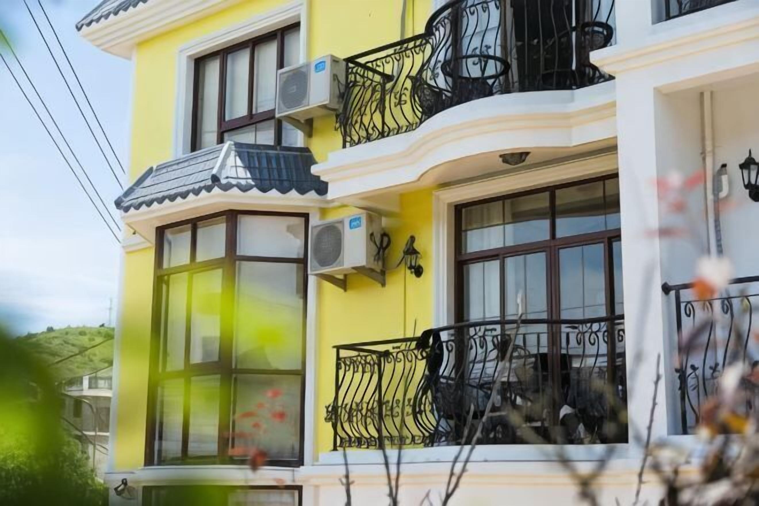 A yellow building with multiple windows and balconies.
