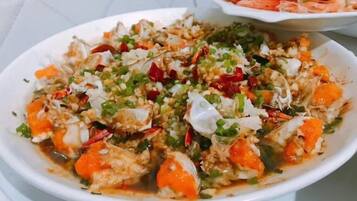 A dish with seafood, vegetables, and a creamy sauce.