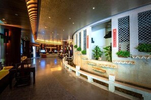 A hotel lobby with a reception desk, seating area, and decorative plants. - Suzhou Yuanqu Xinghai SCHOLARS Hotel (Jinji Lake) (Suzhou)
