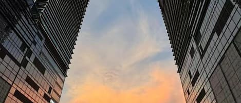 A view of tall buildings with a clear sky and a sunset.
