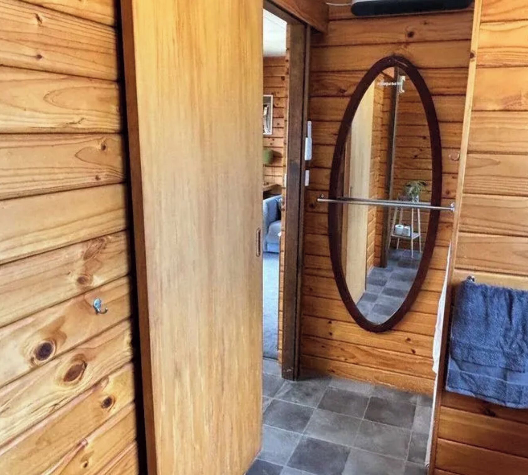 Eine Holztür mit Spiegel und Handtuch an der Wand.