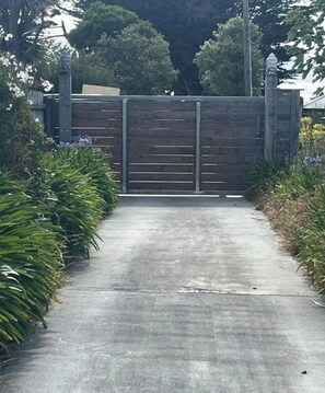 A gated entrance with a concrete pathway leading to a building.
