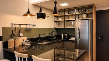 A modern kitchen with a central island, stainless steel appliances, and pendant lighting.