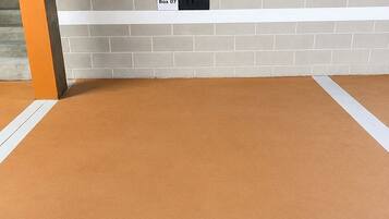 Una habitación con alfombra marrón, zócalo blanco y pared de ladrillo con la etiqueta 'Apto 413 Box 07'.