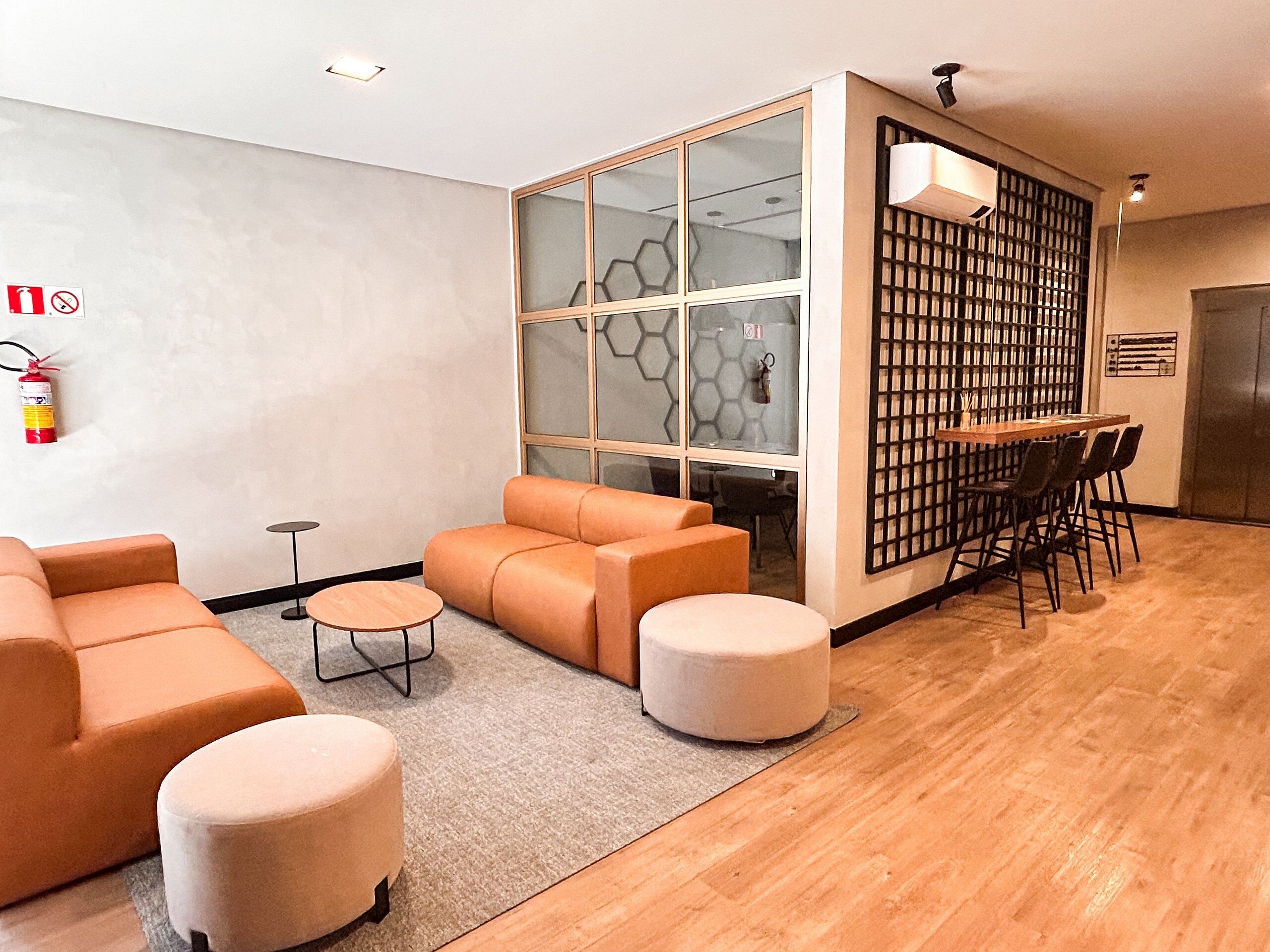 Un interior moderno con sofá, reposapiés y un comedor con sillas y mesa.