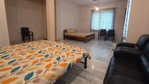 A bedroom with a bed, a sofa, a desk, and a ceiling fan.