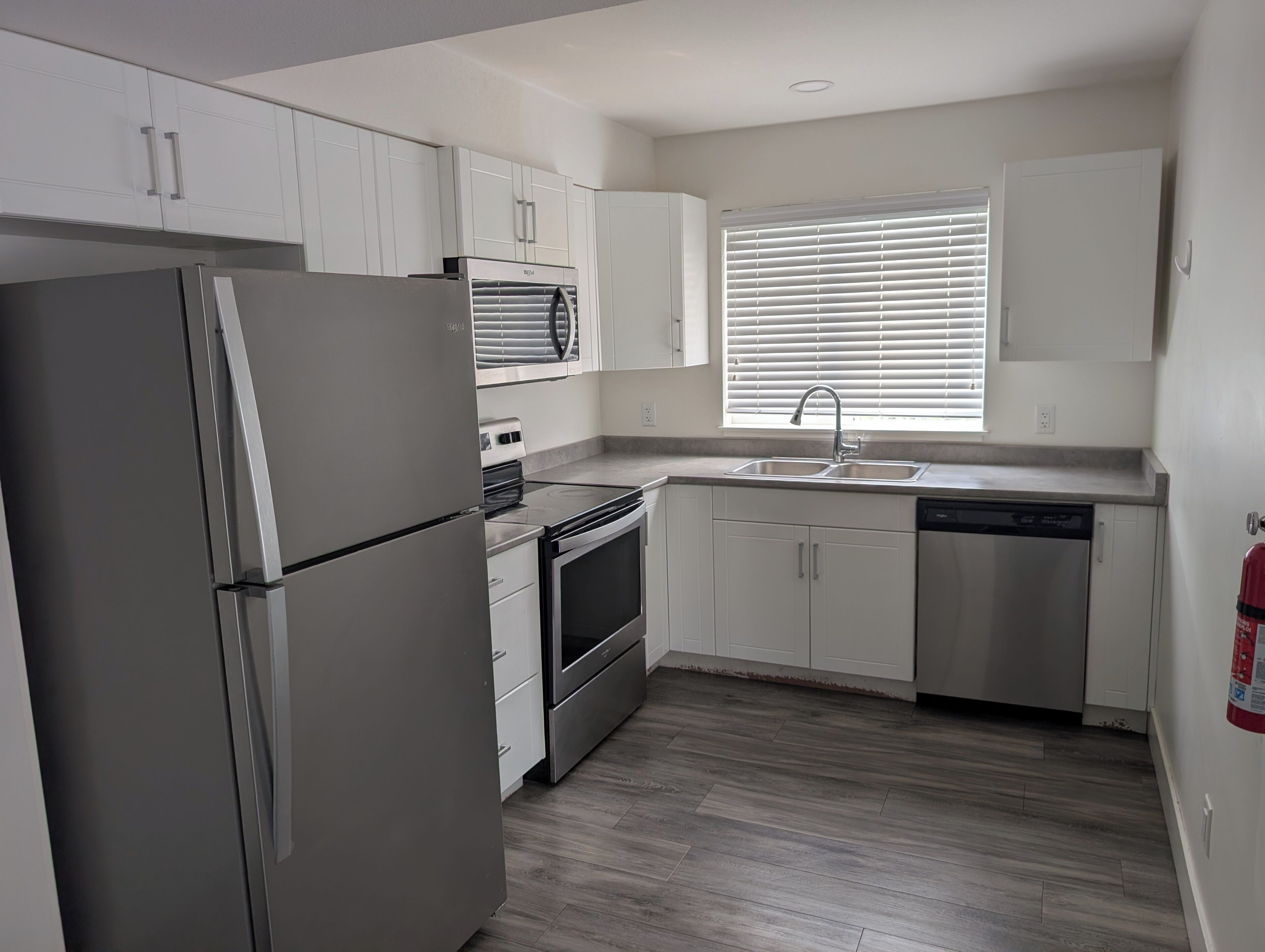 A compact kitchen with a refrigerator, stove, oven, and dishwasher.