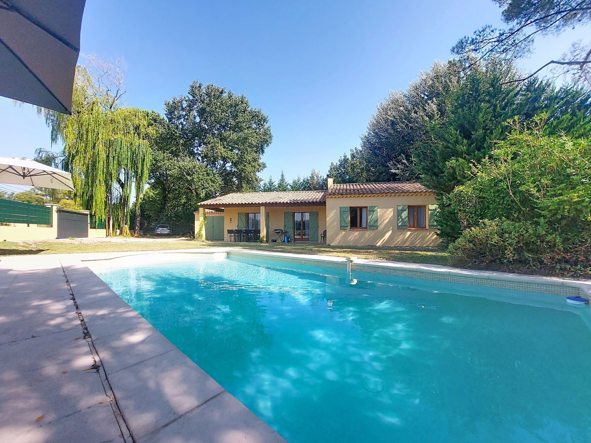 A swimming pool with a house in the background.