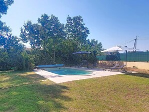 A backyard with a swimming pool, lounge chairs, and a covered area. - La Jeansarde by Interhome (Fox-Amphoux)