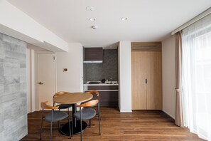 Una cocina moderna con comedor, suelo de madera y vistas al exterior.