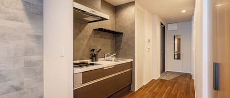 A modern kitchen with a built-in oven, a stainless steel sink, and a wooden countertop.