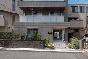 Un edificio moderno con techo plano, amplios ventanales y entrada cubierta.