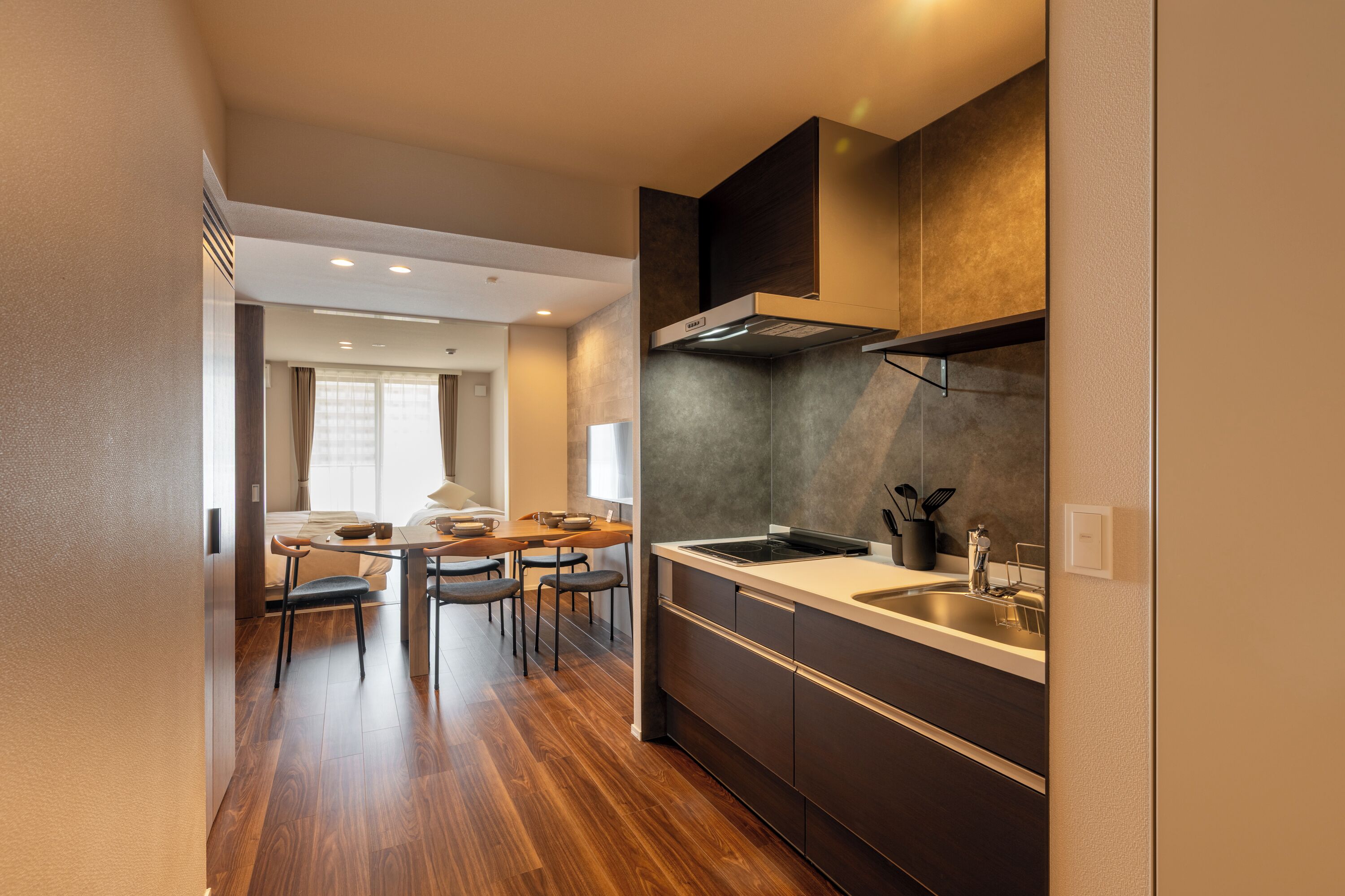 Una cocina moderna con estufa integrada, un fregadero y un comedor con mesa y sillas.