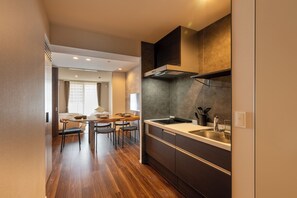 Una cocina moderna con estufa integrada, un fregadero y un comedor con mesa y sillas.