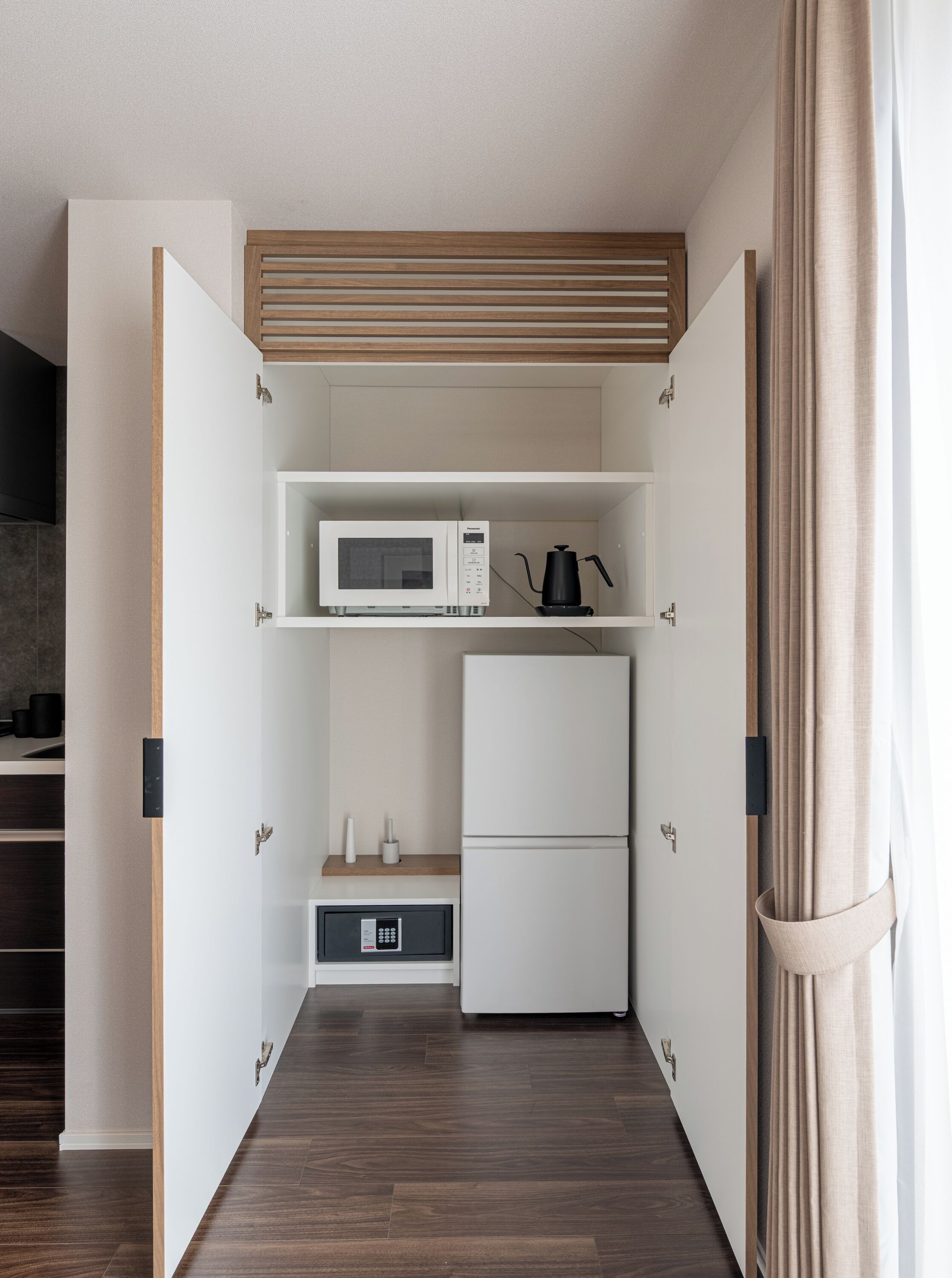 A compact kitchen with a microwave, coffee maker, and refrigerator.