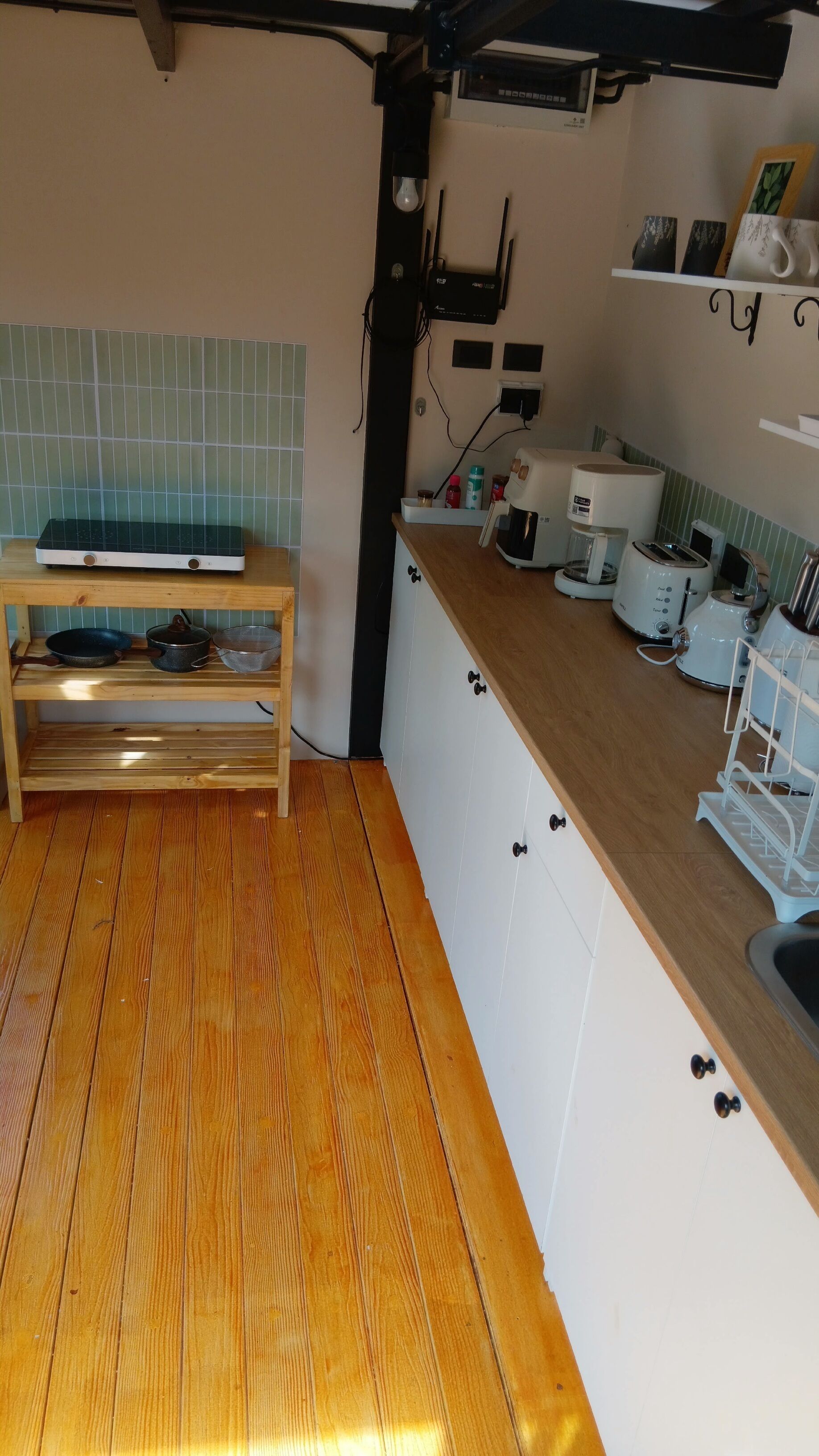 A kitchen with wooden flooring, a built-in stove, a coffee maker, and a toaster.