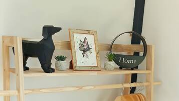 A wooden shelf with a black dog figurine, a framed picture, and a basket labeled 'Home'.