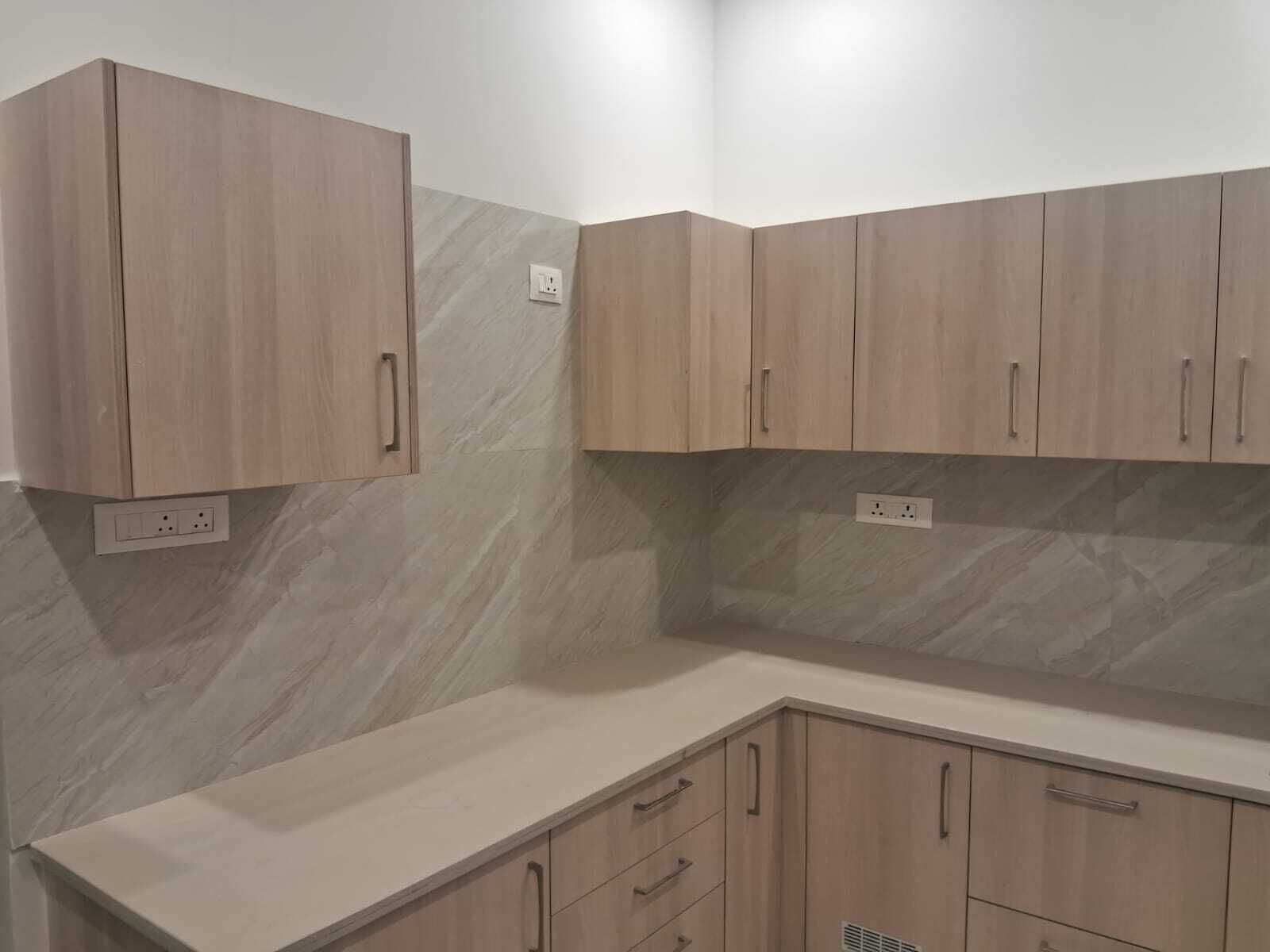 Una cocina con armarios de madera y salpicadero de mármol.