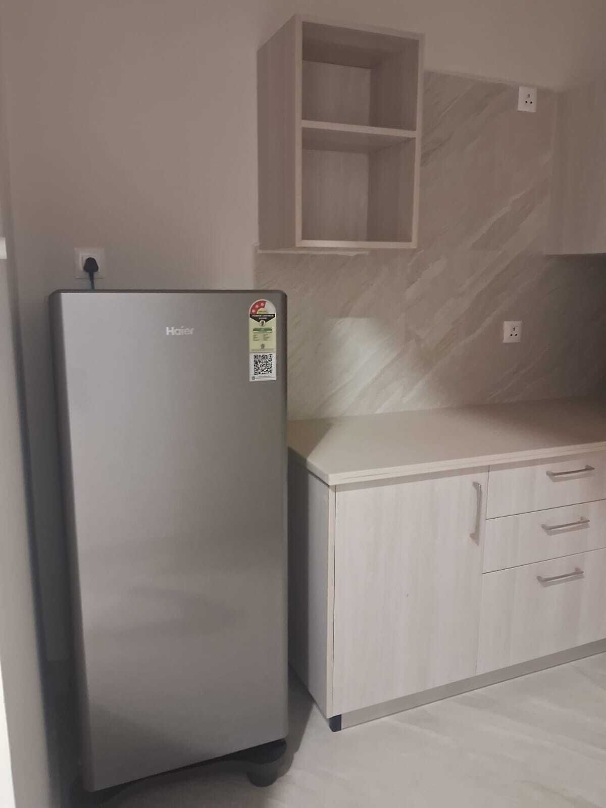 Una cocina con un refrigerador, una encimera y un armario.