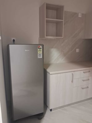 A kitchen with a refrigerator, a countertop, and a cabinet.