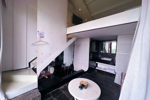 A modern interior with a staircase, a round table, and a view of the outdoors.