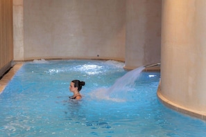 A person in a small indoor pool with a water jet feature. - Horizon Resort Massane (Baillargues)