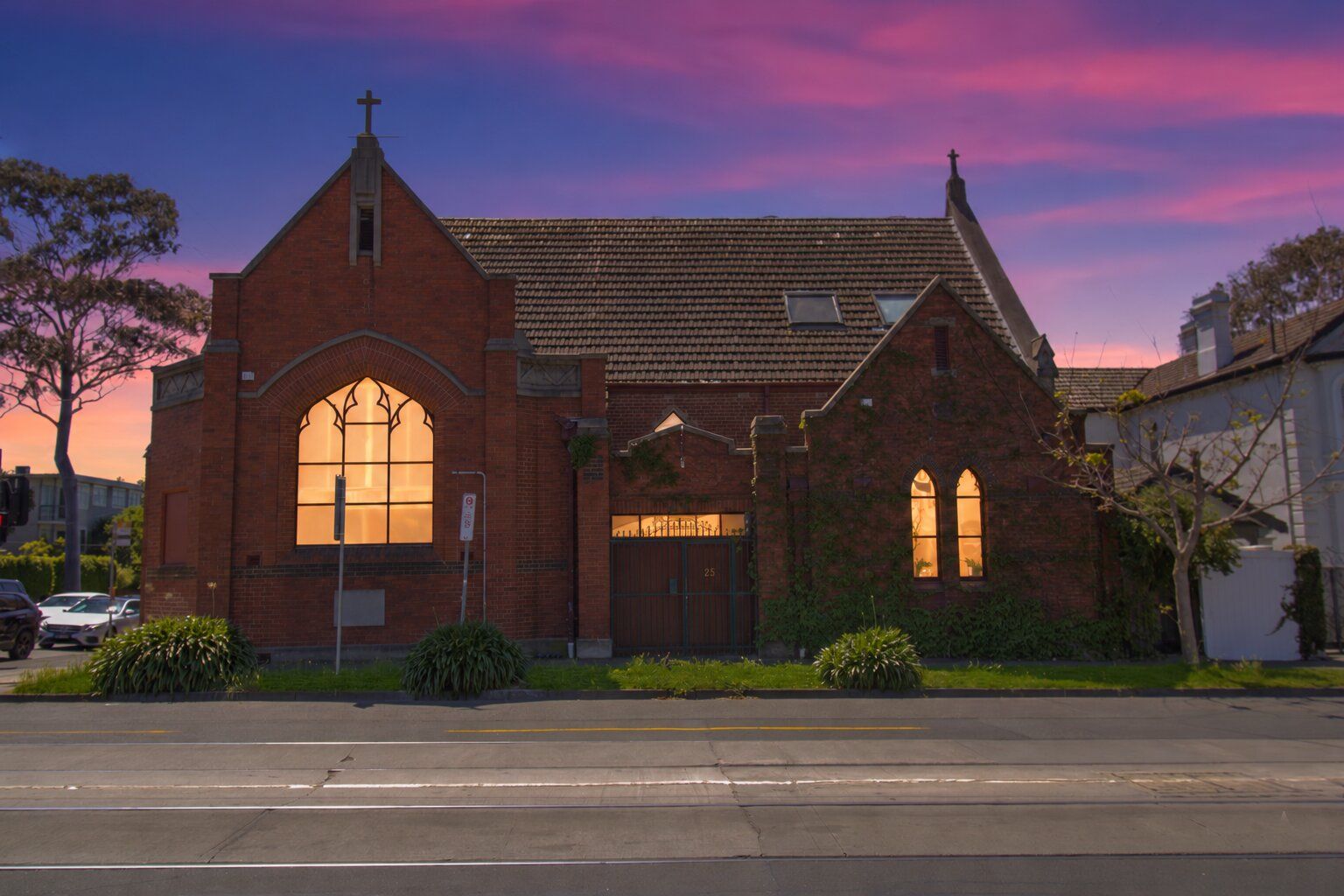 Historic red-brick retreat with glowing windows at sunset