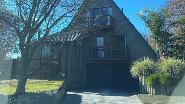 A residential house with a sloped roof, a front porch, and a garage. - A-frame with pool (Cambridge)
