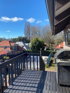 Eine Holterrasse mit Grill und Blick auf Häuser und Bäume.