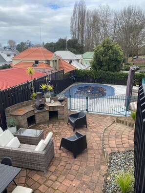 A patio area with a barbecue grill, outdoor seating, and a small pond. - A-frame with pool (Cambridge)