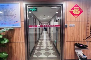 Een hotelgang met een receptiebalie, een kaart en een bord met richtingaanwijzingen.