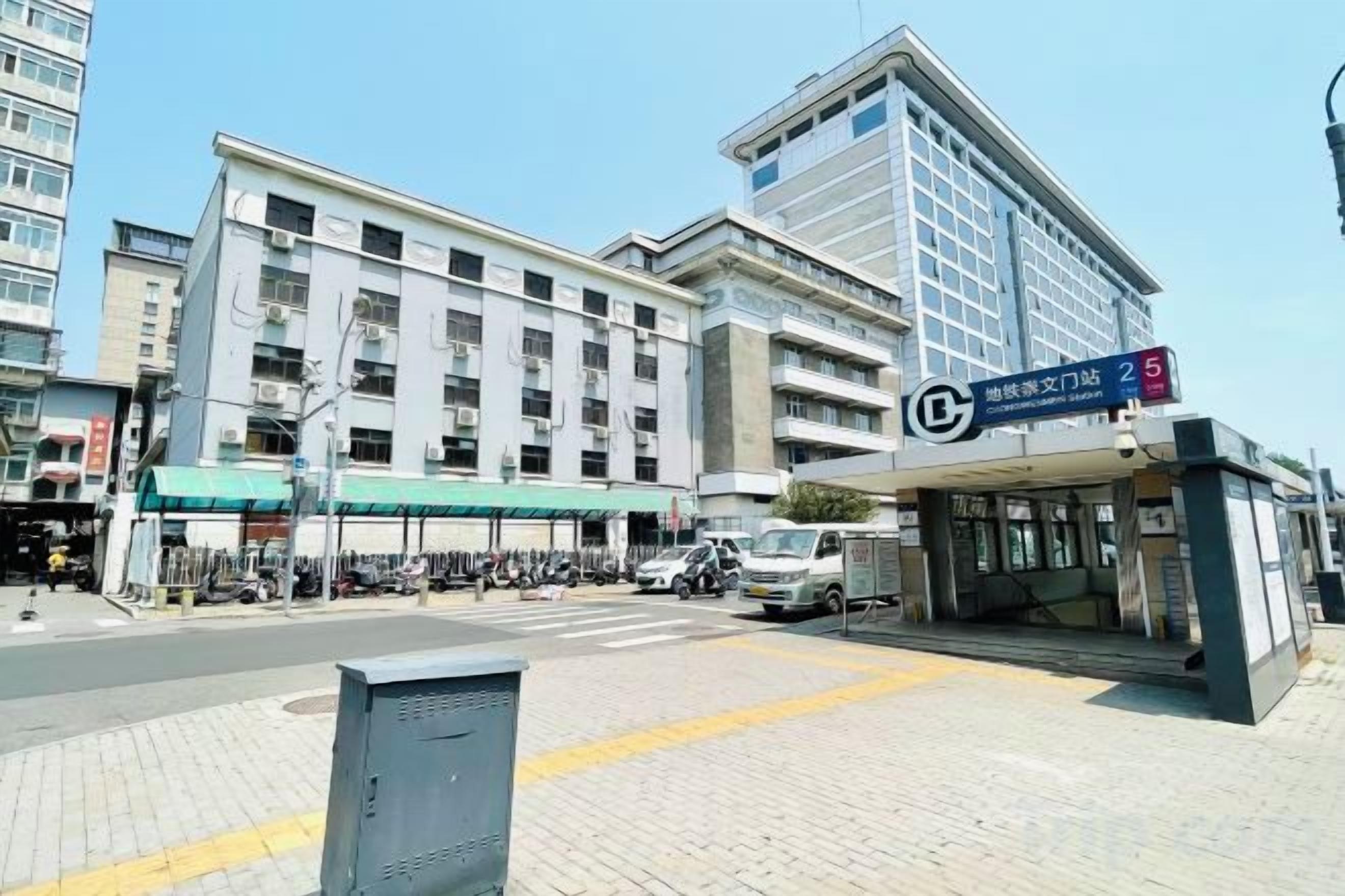 Un edificio de varios pisos con vestíbulo cubierto y un letrero que indica un espacio de oficina o negocios.