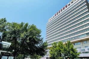 A multi-story building with a modern architectural design, featuring a series of windows and a prominent signage at the top. - Joyinn Hotel (Beijing Tongren Hospital Chong Wen Men Subway Station ) (Beijing)