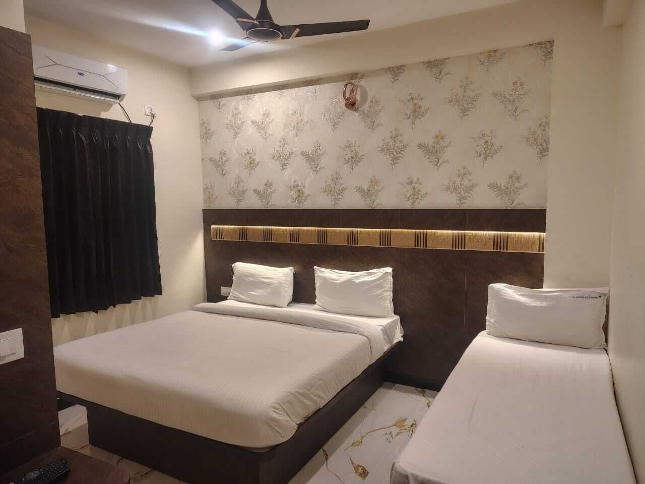 Une chambre d’hôtel équipée d’un lit, d’un ventilateur de plafond et d’un climatiseur fixé au mur.