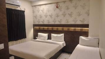 Une chambre d’hôtel équipée d’un lit, d’un ventilateur de plafond et d’un climatiseur fixé au mur.