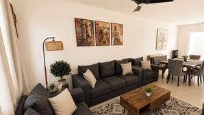 Ein modernes Wohnzimmer mit einer Sofagarnitur, einem Couchtisch und einem Essbereich mit Stühlen und einem Tisch.