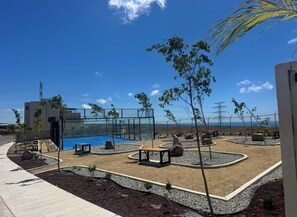 Ein angelegter Außenbereich mit Pool, Sitzgelegenheiten und einer modernen Gebäudestruktur.