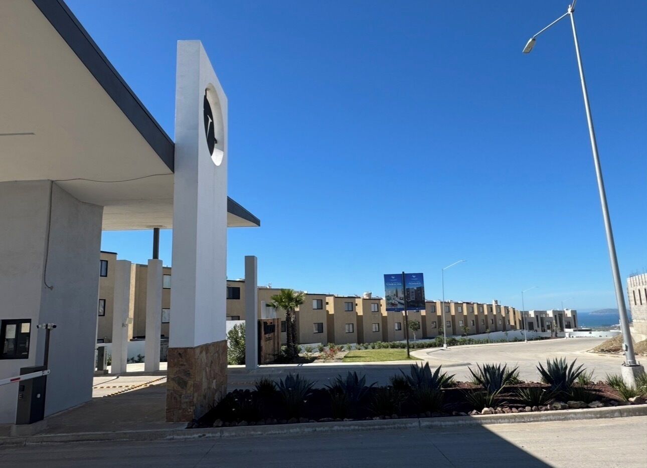 A modern building with a central entrance, a parking area, and a clear view of the surrounding landscape.