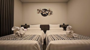 A hotel room with two beds, a ceiling light, and a wall decoration.