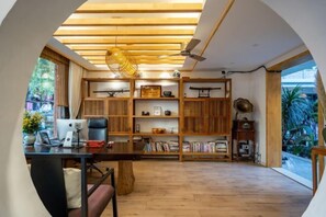 A modern interior with a wooden desk, bookshelves, and a ceiling fan. - Youdu Inn (Dali City)